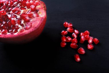 Nar taneleri ve kopya alanı için yer siyah ayna zemin üzerine Beautiful olgun nar.