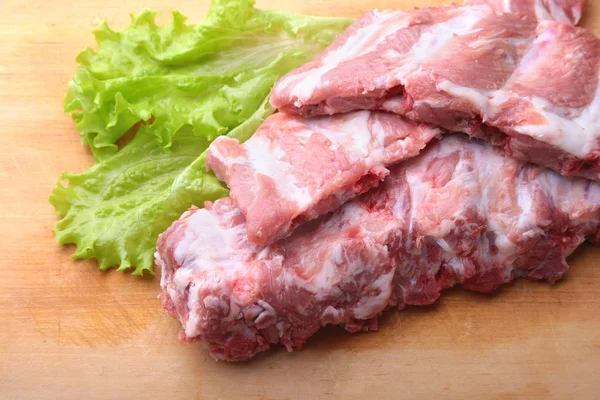 Raw Ribs on a rustic cutting board with salt, pepper and grinder for spices . copy space. Top View. — Stock Photo, Image