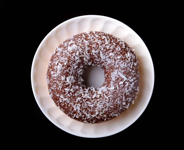 Homemade doughnuts in the glaze, colorful sprinkles on a black background. — Stock Photo, Image