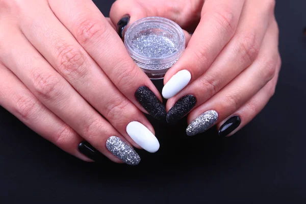 Black, white Nail art manicure. Holiday style bright Manicure with sparkles. Bottle of Nail Polish. Beauty hands. Stylish Nails, Nail Polish