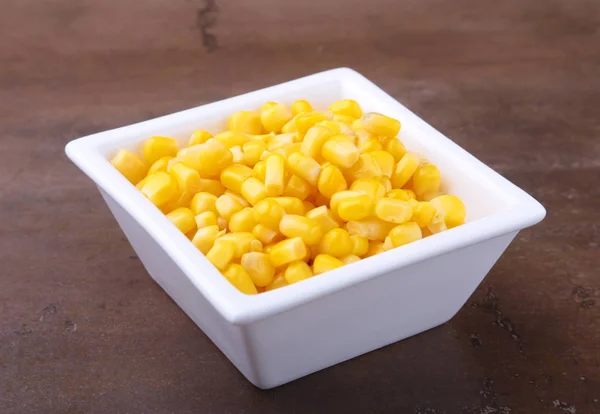 Sweet canned corn in white bowl. Ingredients for salad. Selective focus. — Stock Photo, Image