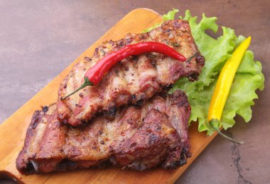 marul yaprakları, sıcak biber ve sos ahşap kesme tahtası üzerinde mangalda kaburga ızgara.