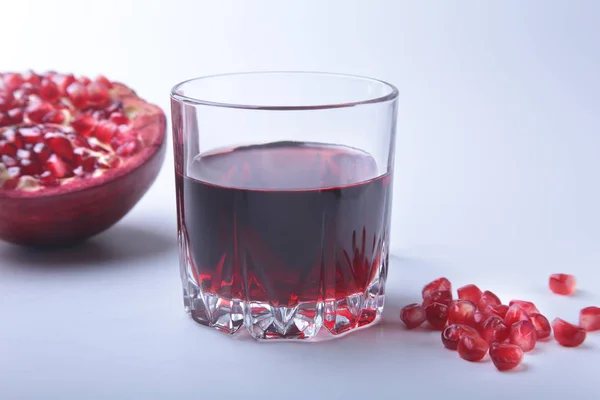 Vidrio con jugo de granada Semillas de granada y hermosa granada madura sobre fondo blanco con lugar para espacio de copia . — Foto de Stock