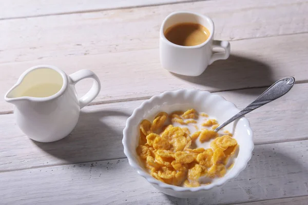 Кукурудзяні пластівці крупи в мисці, склянка з молоком і кепка з кавою еспресо. Ранковий сніданок . — стокове фото