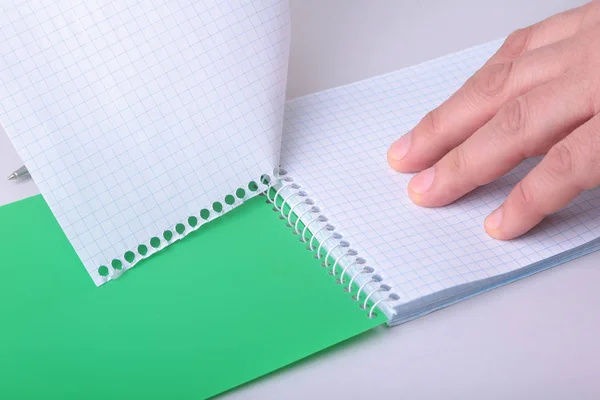 Mãos arrancando a folha de papel de um caderno em espiral . — Fotografia de Stock