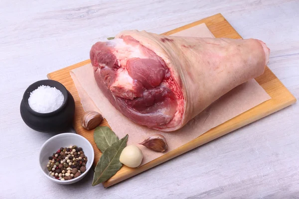 Raw pork knuckle, Aromatic dried bay leaves, garlic, sea salt and spices on a cutting board. Selective focus. Ready for cooking. — Stock Photo, Image