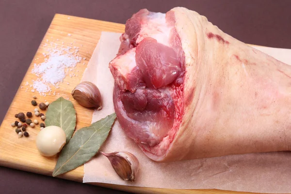 Raw pork knuckle, Aromatic dried bay leaves, garlic, sea salt and spices on a cutting board. Selective focus. Ready for cooking. — Stock Photo, Image