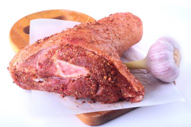 Çiğ domuz knuckle, sarımsak ve baharat bir kesme tahtası üzerinde. Seçici odak. Hazır yemek pişirmek için.