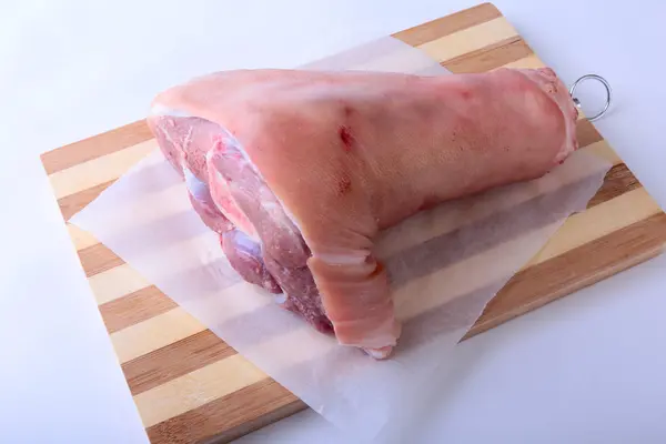 Raw pork knuckle on a cutting board. Selective focus. Ready for cooking. — Stock Photo, Image