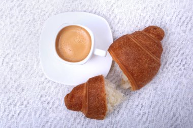 Klasik espresso beyaz Kupası ve kruvasan beyaz arka plan üzerinde. Üstten Görünüm.