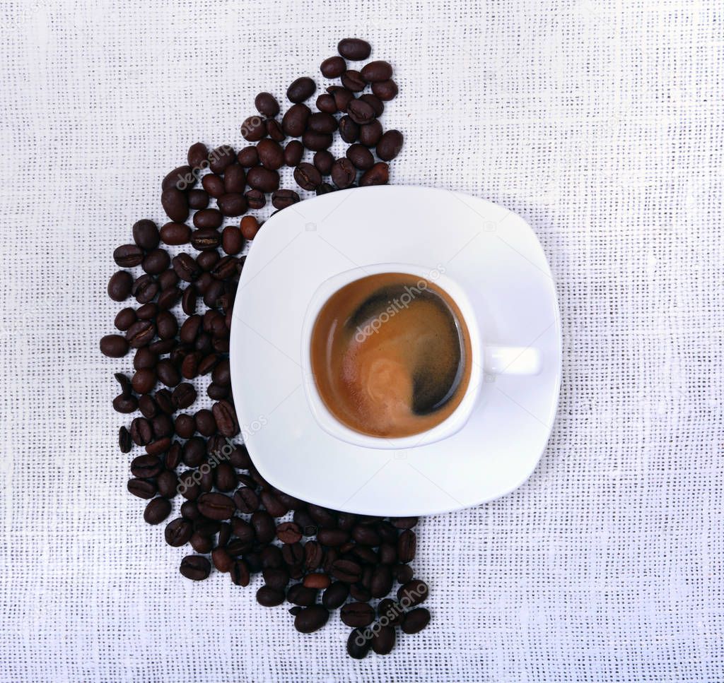 Classic espresso in white cup and coffee beans on white background. Top view.
