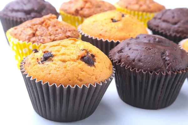 Sortidas com deliciosos cupcakes caseiros com passas e chocolate isolado em fundo branco. Muffins. Vista superior . — Fotografia de Stock