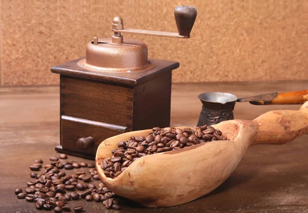 Vieja cucharada de madera con granos de café, molinillo de café y Cezve en la mesa de piedra oscura . — Foto de Stock