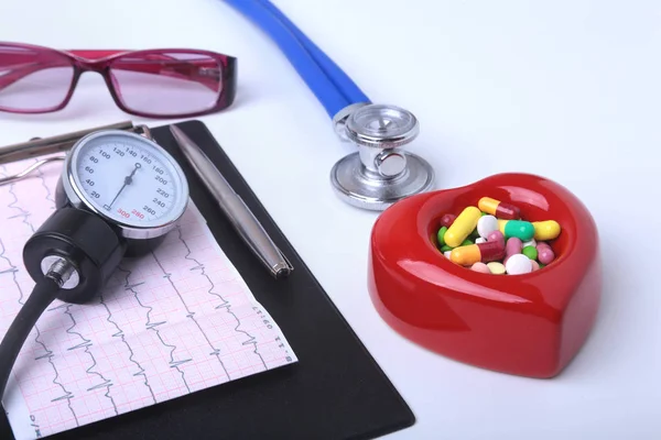 Red heart, asorted pils, glasses and a stethoscope on white background. — Stock Photo, Image