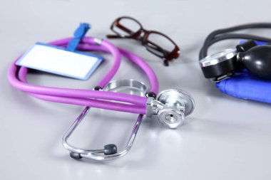 stetoskop, kırmızı kalp, gözlük ve beyaz arka plan üzerinde tansiyon ölçer. Seçici odak.