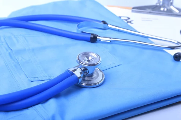 Medizinisches Stethoskop, das auf der Krankenakte des Patienten liegt, rx-Rezept und blaue Arztuniform in Nahaufnahme. Medizinische Hilfe oder Versicherungskonzept. kardiologische Versorgung, Gesundheit, Schutz und Prävention. — Stockfoto