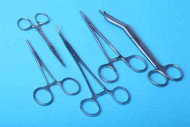 Ameliyat için masaya yerleştirilmiş neşter, pens ve cımbız gibi cerrahi aletler ve aletler..