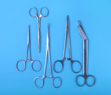 Ameliyat için masaya yerleştirilmiş neşter, pens ve cımbız gibi cerrahi aletler ve aletler..