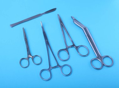 Ameliyat için masaya yerleştirilmiş neşter, pens ve cımbız gibi cerrahi aletler ve aletler..