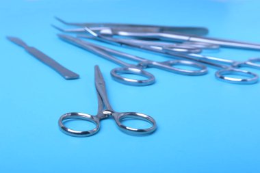 Ameliyat için masaya yerleştirilmiş neşter, pens ve cımbız gibi cerrahi aletler ve aletler..