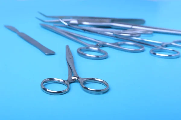 Przyrządy i narzędzia chirurgiczne, w tym skalpele, kleszcze i pęseta, ułożone na stole do operacji. — Zdjęcie stockowe