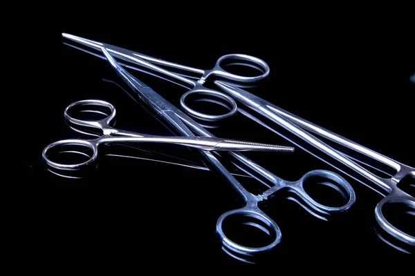 Instrumenty chirurgiczne i narzędzi takich jak Skalpele, Pincety i szczypce na tle czarnego lustra. — Zdjęcie stockowe
