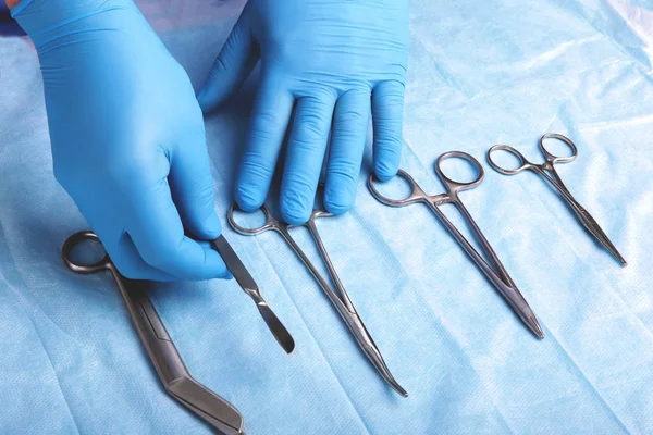 Detalhe tiro de instrumentos de cirurgia esterilizados com uma mão agarrando uma ferramenta  , — Fotografia de Stock