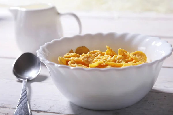 Copos de maíz cereales en un tazón y un vaso con leche. Desayuno por la mañana . —  Fotos de Stock