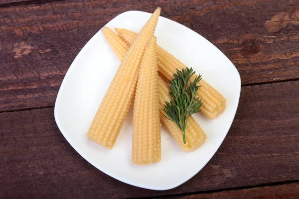 Mini mazorca de maíz conservada en placa sobre tabla de madera . —  Fotos de Stock