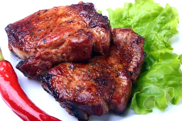 Steak z grilovaného masa a chilli s rajčaty, salátových listů na bílé plotně. — Stock fotografie