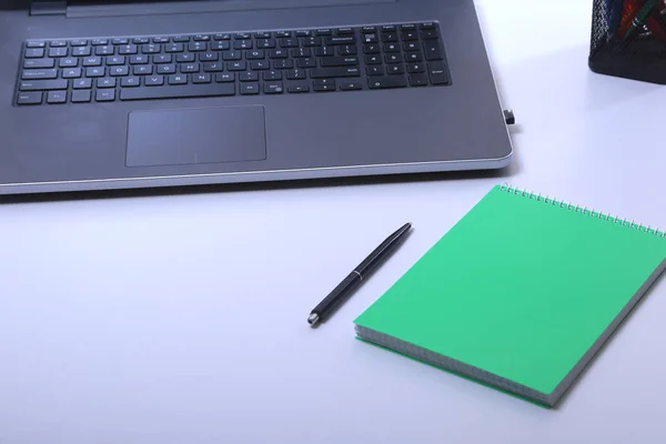 Moderní bílý kancelářské stůl stůl s laptop, smartphone a další potřeby. Prázdné notebook stránka pro vstup textu uprostřed. Pohled shora. — Stock fotografie