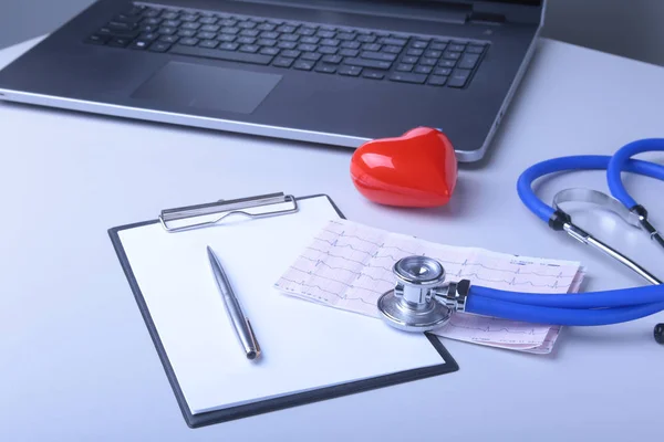 Lugar de trabajo del médico con portátil, estetoscopio, corazón rojo y prescripción RX en la mesa blanca. vista superior . — Foto de Stock