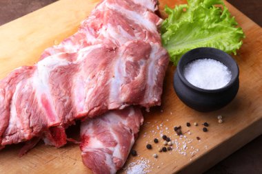 Tuz, biber ve baharat değirmeni ile bir rustik kesme tahtası üzerinde ham kaburga. kopya alanı. Üstten Görünüm.