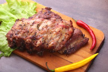 marul yaprakları, sıcak biber ve sos ahşap kesme tahtası üzerinde mangalda kaburga ızgara.