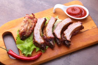 marul yaprakları, sıcak biber ve sos ahşap kesme tahtası üzerinde mangalda kaburga ızgara.