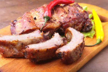 marul yaprakları, sıcak biber ve sos ahşap kesme tahtası üzerinde mangalda kaburga ızgara.