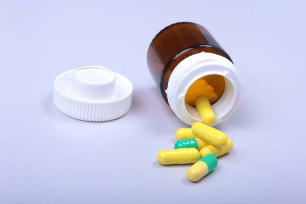 Coloridas pastillas y cápsulas médicas en la mesa blanca con espacio para el texto . — Foto de Stock