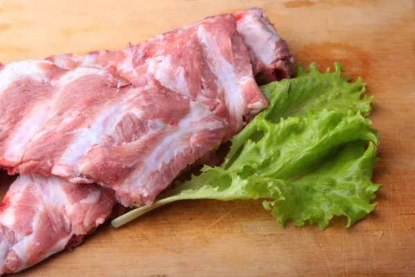 Raw Ribs on a rustic cutting board with salt, pepper and grinder for spices . copy space. Top View. — Stock Photo, Image