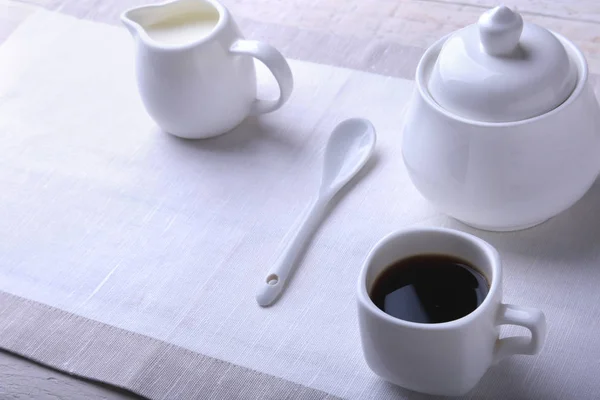 Cup of hot coffee espresso, coffee beans, jug of milk, and bowl with sugar on white background for copy space. Coffee concept. — Stock Photo, Image