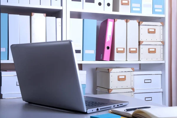 Moderno interior de oficina con laptop, sillas y librerías — Foto de Stock