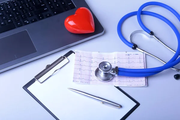 Local de trabalho do médico com laptop, estetoscópio, coração vermelho e prescrição de RX na mesa branca. vista superior . — Fotografia de Stock