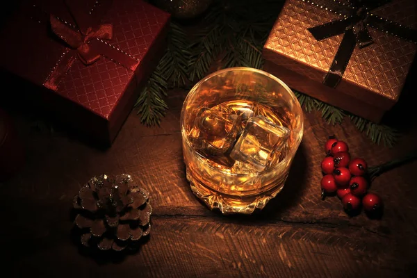 Glas met cognac of whisky, kerstballen en kaarsen. Nieuwjaarsboom, ballen en glas met alcohol. Fijne feestdagen decoratie. — Stockfoto