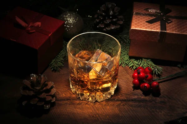 Glas met cognac of whisky, kerstballen en kaarsen. Nieuwjaarsboom, ballen en glas met alcohol. Fijne feestdagen decoratie. — Stockfoto