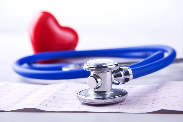 Медичний стетоскоп і червоне серце лежать на кардіограмі крупним планом. Медична допомога, профілактика, профілактика захворювань або концепція страхування. Кардіологічна допомога . — стокове фото