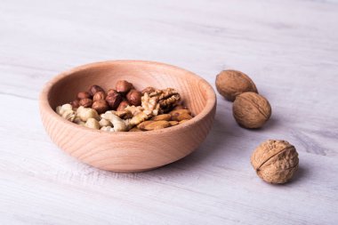 Ahşap servis kaşığı ve ahşap masada fındıklar. Yakın plan..