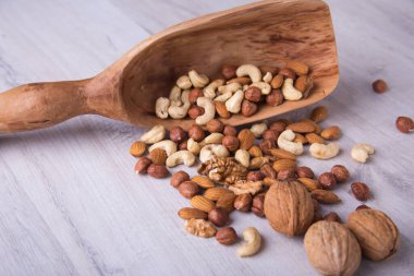 Ahşap servis kaşığı ve ahşap masada fındıklar. Yakın plan..