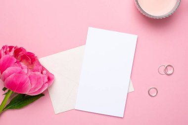 Üzerinde güzel bir çiçek şakayığı ve pastel pembe arka planda kadın aksesuarları olan tebrik kartı. Yazın moda rengi..