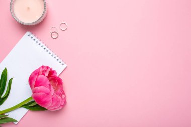 Güzel pembe şakayık çiçeği ve pastel pembe arkaplan üzerine yazdığın metin için kopya alanı olan bir defter.