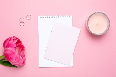 Güzel pembe şakayık çiçeği ve pastel pembe arkaplan üzerine yazdığın metin için kopya alanı olan bir defter.