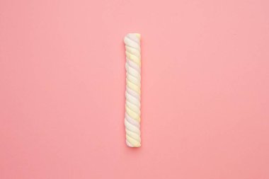 Pembe arka planda renkli uzun marşmelovlar, lezzetli tatlılar bembeyaz.